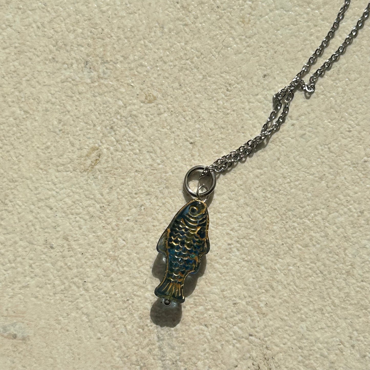 Gold on transparent dark blue fish necklace