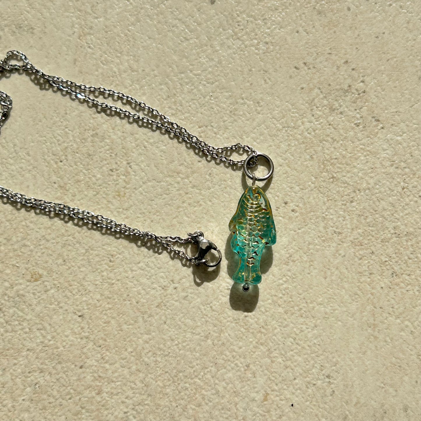 Transparent blue and gold fish necklace