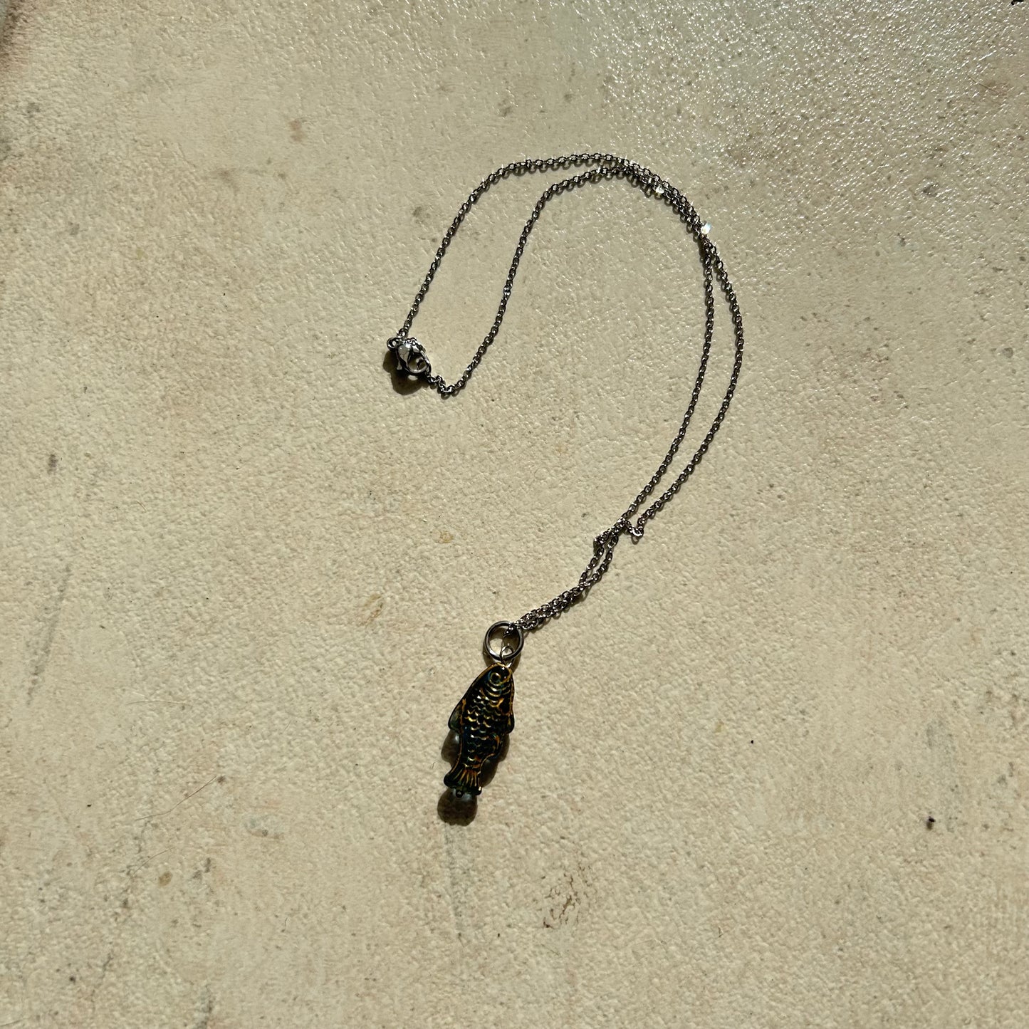 Gold on transparent dark blue fish necklace